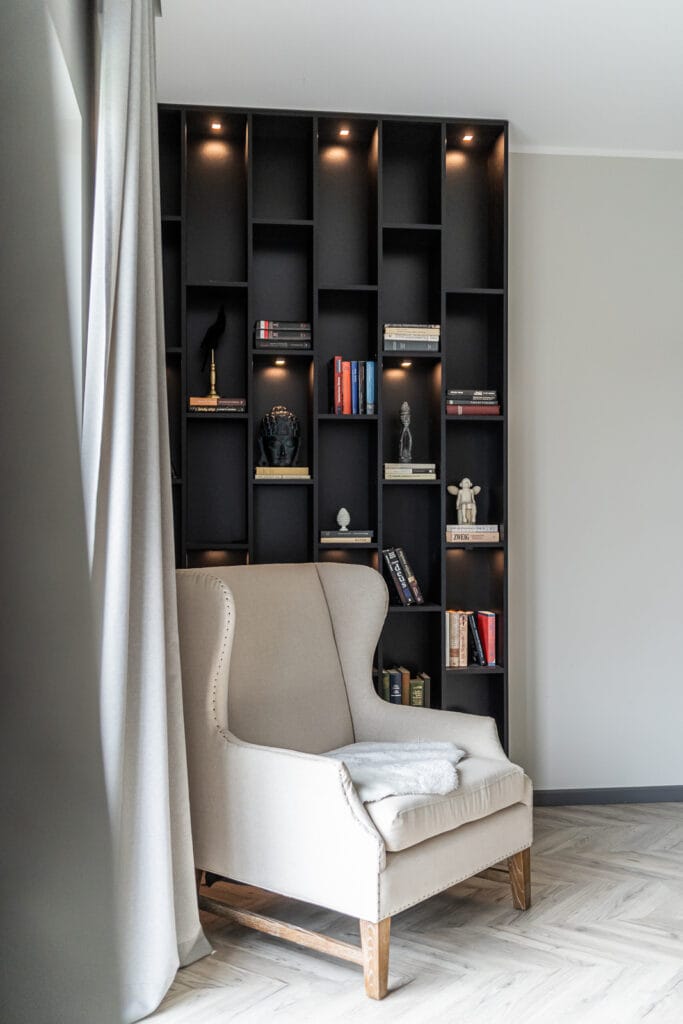 08_namo_interjeras_vilniuje_eglutes_grindys_parketas_sviesus_fotelis_tamsaus_medzio_knygu_lentynos