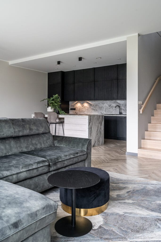 09_namo_interjeras_vilniuje_sujungta_virtuve_svetaine_tamsiai_zalia_sofa_juoda_virtuve_sala