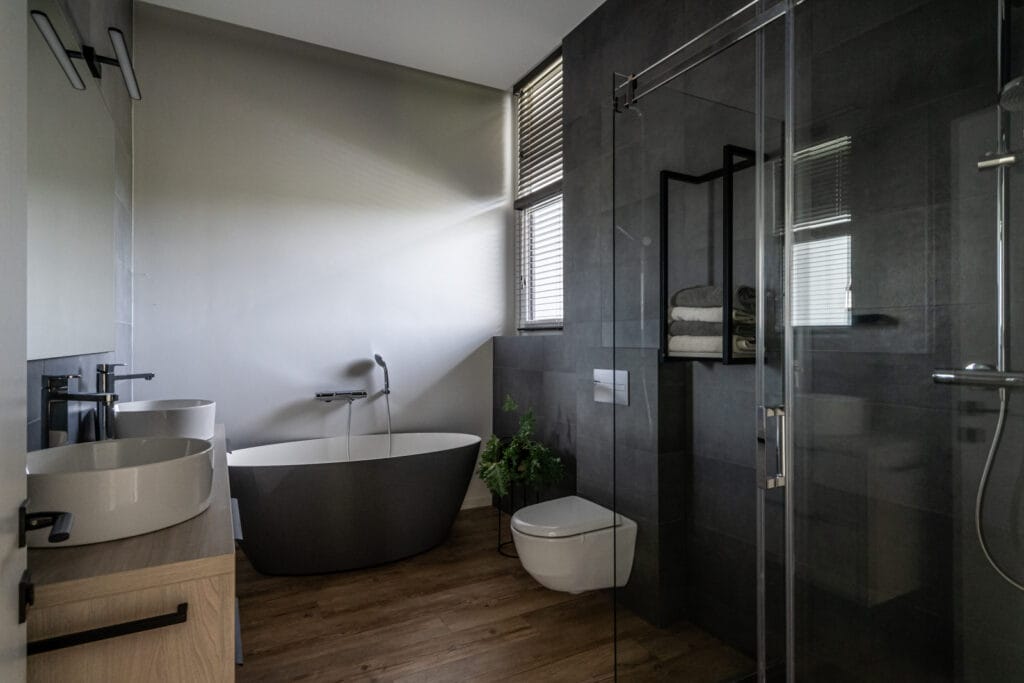 26_modernus_vonios_kambarys_su_apvalia_pilka_vonia_medzio_spintelemis_name_vilniuje