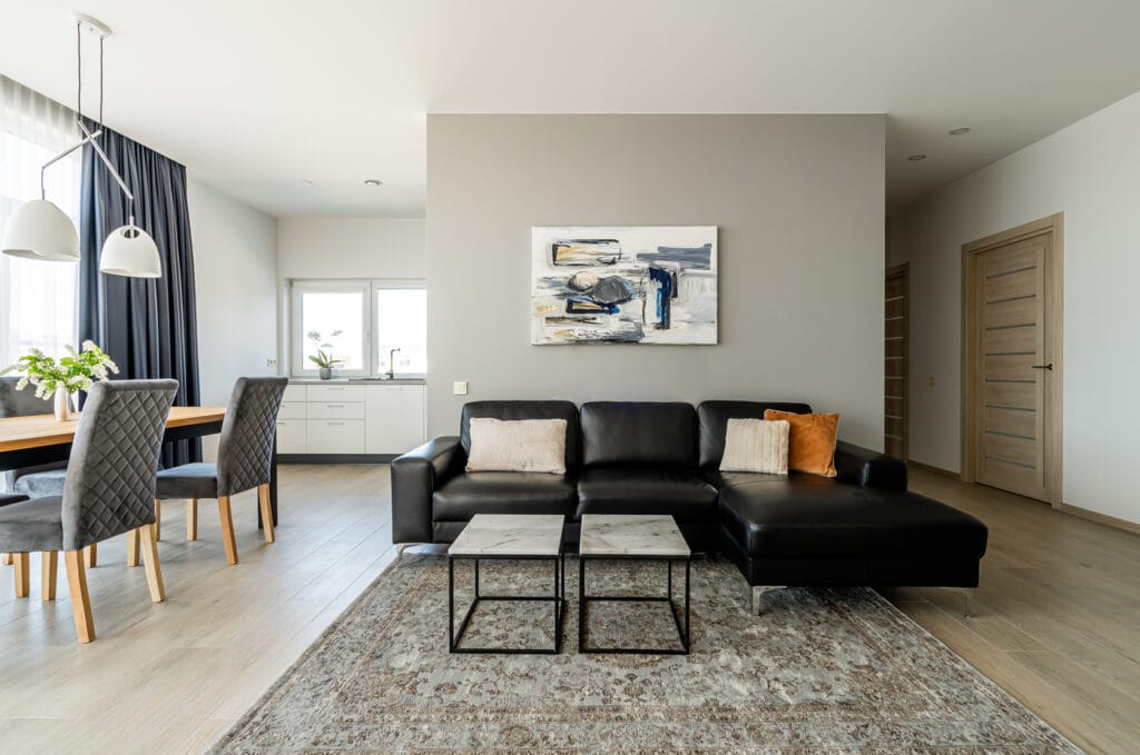 7_namo_interjeras_svetainė_bendra_virtuve_odine_sofa_medzio_grindys