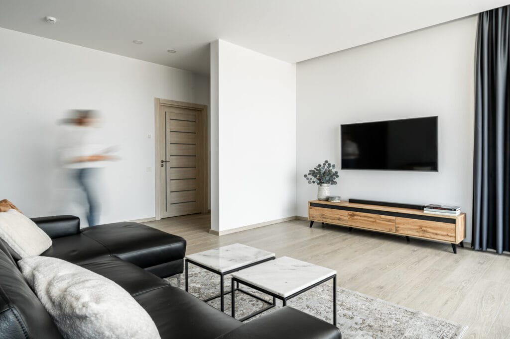 8_svetaines interjeras_baltos_sienos_pilkos_uzuolaidos_odine_sofa